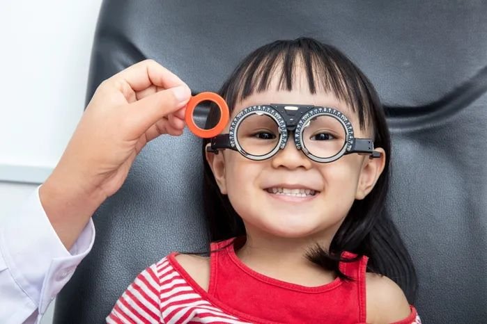 Child wearing eyeglasses reading a book